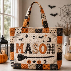 May include: A quilted tote bag featuring a patchwork pattern of orange, black, and cream Halloween-themed fabrics. The centre panel displays the name MASON in large letters, surrounded by embroidered ghosts, bats, stars, and a witch's broom.