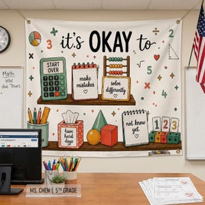 May include: A white wall tapestry featuring the text 'it's OKAY to' above illustrations of a calculator, notebooks, an abacus, and blocks. The text includes 'start over', 'make mistakes', 'solve differently', 'have hard days', and 'not know yet'.