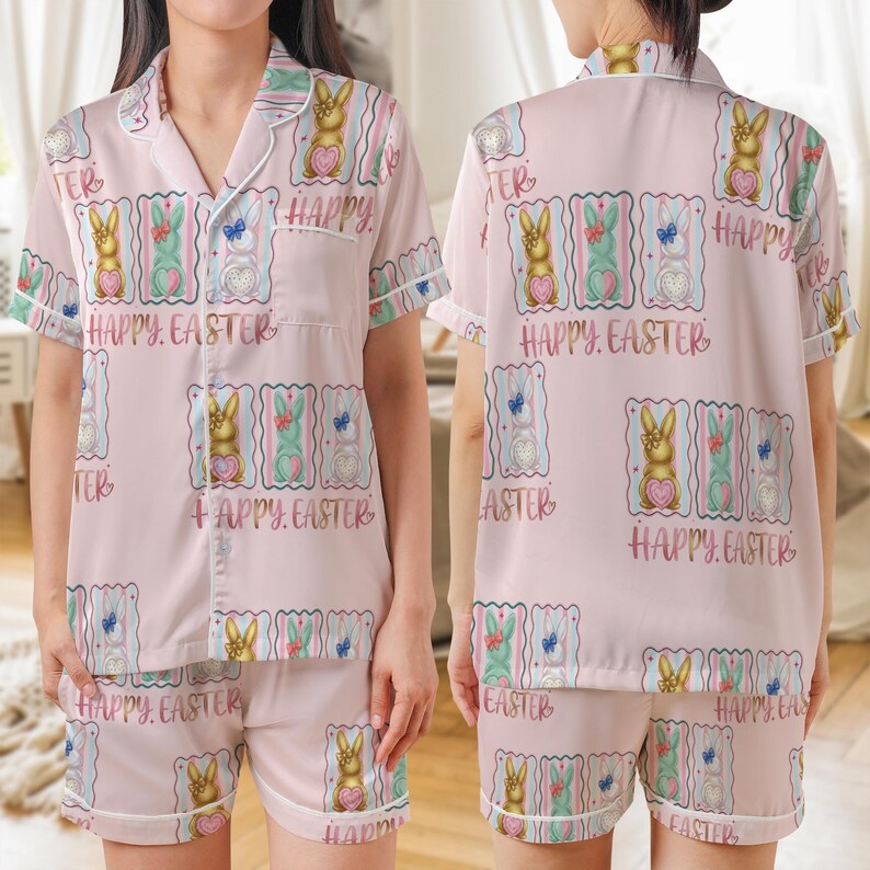 K&ouml;nnte beinhalten: Hellrosa Pyjama-Set mit einem sich wiederholenden Muster aus Osterhasen, Herzen und Schmetterlingen. Der Text "HAPPY EASTER" ist auf dem Design aufgedruckt. Das Set beinhaltet ein kurz&auml;rmeliges Hemd und passende Shorts.