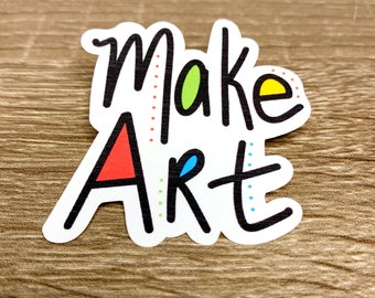 May include: White sticker with black lettering that says "Make Art" with colorful dots and shapes around the letters.