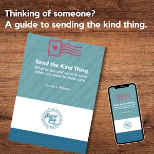 May include: A book and a smartphone displaying the cover of "Send the Kind Thing" on a wooden surface. The book has a teal cover with white text and a red heart design. The smartphone shows the same design.