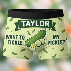 May include: Light green boxer briefs with a black waistband. The briefs feature a large green pickle graphic with the text "TAYLOR" above it. The text "WANT TO TICKLE MY PICKLE?" is also printed on the briefs.