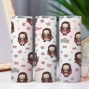 May include: Three cylindrical tumblers featuring a repeating pattern of a chibi-style character with long dark hair, a bamboo muzzle, and a pink kimono. The white background includes small pink flowers, butterflies, bows, stars, and the text Demon Slayer.