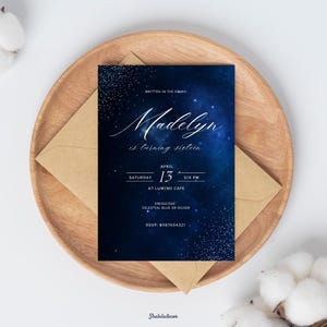 May include: A navy blue invitation card with white script that reads "Madelyn is turning sixteen." The card includes event details: April 15, Saturday, 6 PM, at Lumino Cafe. Dress code: Celestial Blue or Silver. RSVP: 6987654321.