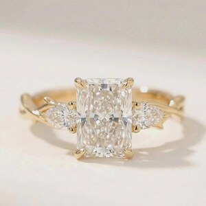 Elegant three-stone pear diamond engagement ring by ExcellentJewels, featuring a radiant center diamond and two accent stones in a custom gold setting. This fine jewelry piece offers timeless beauty, sparkling brilliance, and sophisticated design, making it perfect for proposals, anniversaries, or as a luxurious gift for someone special.