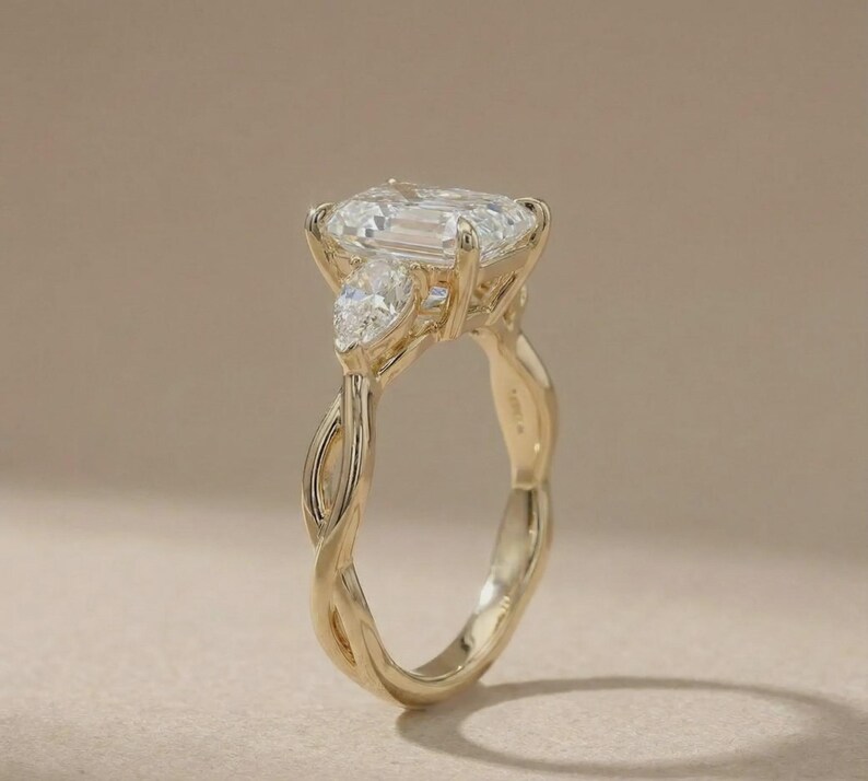 Custom gold radiant three-stone pear diamond ring by ExcellentJewels, designed for elegant engagements. The pear-shaped center diamond shines brilliantly with two sparkling side stones, offering a luxurious and timeless design. Ideal as a fine jewelry gift for anniversaries, proposals, or personal collection, combining classic charm with modern refinement.