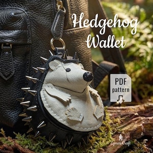 Puede incluir: Un monedero con forma de erizo, en blanco y negro, con púas plateadas alrededor del cuerpo. El monedero cuelga de una mochila de cuero negro. El texto "Hedgehog Wallet" y "PDF pattern" está presente.