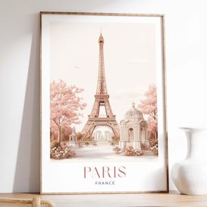 Könnte beinhalten: Ein gerahmter Aquarelldruck mit dem Eiffelturm in Paris, Frankreich. Das Kunstwerk hat eine weiche, pastellfarbene Farbpalette mit rosa Kirschblüten und einer weißen Kuppelstruktur. Die Wörter "PARIS" und "FRANCE" sind unten aufgedruckt.