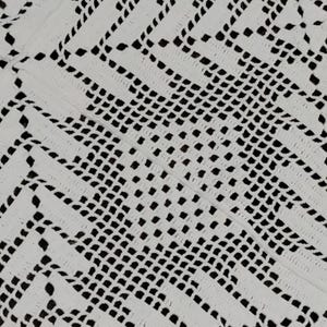 May include: Close-up of a white, intricately crocheted textile. The pattern features a repeating geometric design with open spaces, creating a delicate, lace-like appearance. The texture is soft and detailed, with a focus on the craftsmanship.