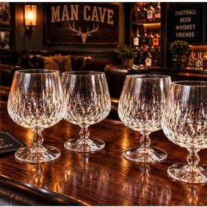 May include: Four clear crystal brandy snifters featuring a diamond-cut pattern on the bowl and a short, rounded stem. Each glass has a wide, circular base and a tapered rim, designed for serving spirits in a set of four matching pieces.