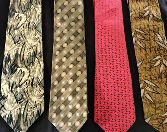 May include: Four neckties with various patterns. One tie has a black and white abstract design, another has a brown and white polka dot pattern, a third is red with a black geometric pattern, and the last is brown with a leaf design.
