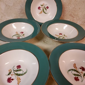 May include: Set of five white soup bowls with a green rim and gold trim. Each bowl features a floral design with red flowers and green leaves.
