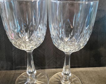 May include: Two clear glass wine glasses with a diamond pattern. The glasses have a tall stem and a wide base.