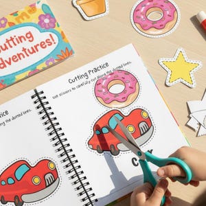 Può includere: Un libro di attività per bambini con il titolo "Cutting Adventures!" è aperto su una pagina con un'illustrazione di un'auto rossa. Un bambino usa forbici turchese per ritagliare l'auto.