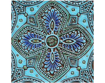May include: A blue and green ceramic tile with an intricate geometric pattern. The tile has a raised design and a glossy finish.