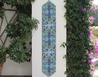 May include: A vertical wall tile with a blue, green, and white geometric pattern. The tile is made of ceramic and has a glossy finish.