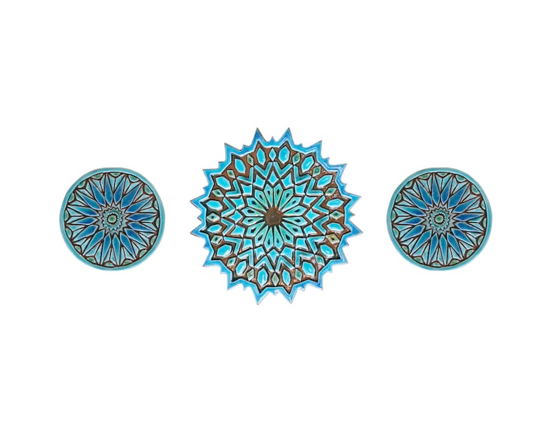 May include: Three decorative ceramic plates with intricate blue and brown geometric patterns. The center plate is larger than the two smaller plates.