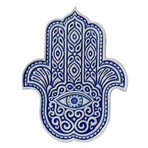 Op de afbeelding: Een blauwe en witte keramische hamsa-hand met ingewikkelde details en een blauw oog in het midden. De hamsa is een symbool van bescherming en geluk.