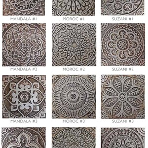 May include: A set of 12 decorative tiles featuring intricate patterns inspired by Moroccan, Mandala, and Suzani designs. The tiles are made of a textured material with a silver-grey color.