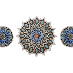 May include: Three ceramic wall decorations featuring intricate geometric patterns in shades of blue, green, and gold. The largest piece is a starburst design, while the two smaller pieces are round.