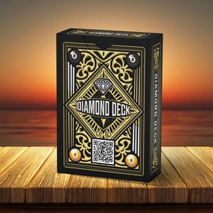 May include: A black Diamond Deck playing card box with gold and white accents. The box features the text "DIAMOND DECK" in a diamond shape, along with the number 8 and 9 billiard balls. The box is on a wooden surface.