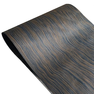 May include: A rolled sheet of wood veneer featuring a dark brown and black striped pattern. The wood grain has a wavy, flowing appearance, creating a textured surface. The edge of the sheet is visible, revealing a dark backing.