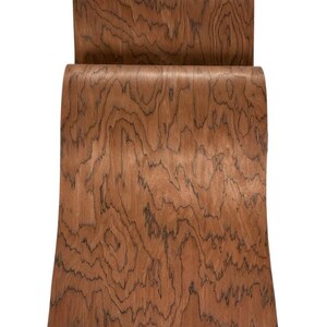 K&ouml;nnte beinhalten: Ein Holzstuhl mit geschwungener R&uuml;ckenlehne und Sitzfl&auml;che. Der Stuhl besteht aus rotbraunem Holz mit dunklen, wirbelnden Maserungsmustern. Das Design ist modern und minimalistisch, geeignet f&uuml;r den Heim- oder B&uuml;rogebrauch.