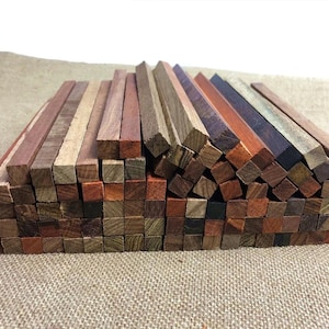Peut inclure: Un assortiment de petits blocs de bois carrés et rectangulaires, dans diverses nuances de marron, de rouge et de beige. Les blocs sont empilés, mettant en valeur le grain et les variations de couleur du bois.