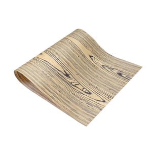 May include: A flexible sheet of wood veneer featuring a light tan base color with prominent, dark brown, elongated grain patterns that run longitudinally across the surface, creating a high-contrast, linear, and organic wood texture.