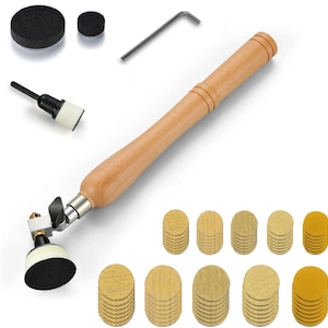 May include: A wood-handled rotary tool with a metal attachment head, a black and white sanding pad, an L-shaped hex key, and multiple stacks of circular abrasive sanding discs in varying shades of tan, yellow, and black for surface finishing.