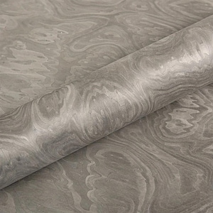 May include: A roll of gray marbled paper with a swirling pattern. The paper has a smooth, glossy finish and a subtle variation in tone, creating a sense of depth and texture. The design resembles natural stone.