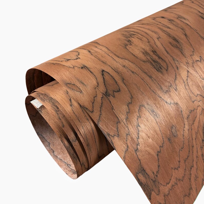 K&ouml;nnte beinhalten: Eine gerollte Holzfurnierplatte, die eine satte braune Farbe mit dunklen, wirbelnden Maserungsmustern zeigt. Das Holz scheint frisch geschnitten zu sein, mit einer glatten Oberfl&auml;che und sichtbarer Textur. Die Rolle ist teilweise abgerollt.