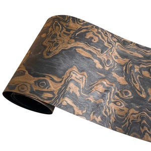 May include: A roll of wood veneer with a striking pattern of swirling dark gray and brown tones. The wood grain creates a natural, organic design. The veneer is rolled up, showing the dark underside.