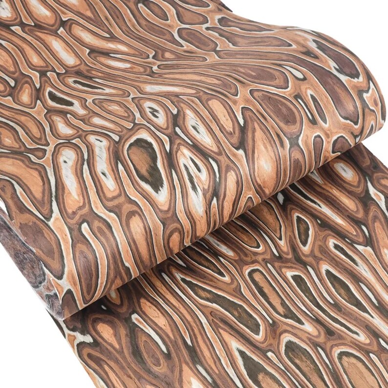 Puede incluir: Un rollo de papel estampado marr&oacute;n y beige con un dise&ntilde;o de vetas de madera. El papel presenta un patr&oacute;n repetitivo de formas y l&iacute;neas org&aacute;nicas, creando una apariencia texturizada. Los colores var&iacute;an del beige claro al marr&oacute;n oscuro.