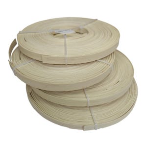 Op de afbeelding: Vier rollen lichtgekleurde fineerbanden zijn op elkaar gestapeld. Elke rol is strak opgerold en vastgezet met een witte plastic band. Het fineer lijkt een natuurlijke houttint te hebben, geschikt voor meubel- of houtbewerkingsprojecten.