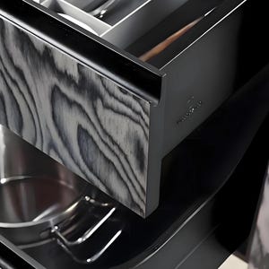 Puede incluir: Primer plano de un caj&oacute;n de cocina con un patr&oacute;n de vetas de madera en negro y gris. El caj&oacute;n est&aacute; abierto, revelando una olla y utensilios de acero inoxidable. El interior del caj&oacute;n es negro y se ve una cuchara de madera.