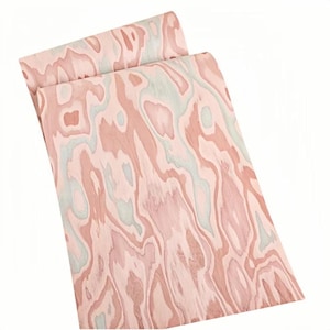 May include: Two sheets of wood veneer with a unique, swirling grain pattern. The veneer features a blend of pink, light blue, and brown tones, creating a natural, organic aesthetic. The sheets are slightly curled, showcasing the wood's flexibility.