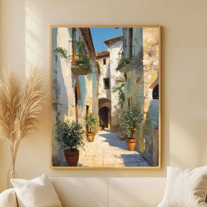 Peut inclure: Peinture encadrée représentant une ruelle italienne ensoleillée. L'œuvre d'art présente des bâtiments avec des balcons, des plantes en pot et un chemin pavé. La palette de couleurs comprend des tons chauds de beige, de brun clair et de bleu, créant une atmosphère sereine et accueillante.
