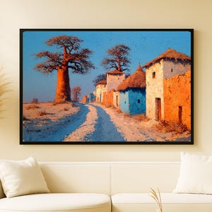 Peut inclure: Peinture encadrée représentant un village africain. L'œuvre montre un chemin de terre passant devant des bâtiments colorés aux toits de chaume. Un grand baobab se détache sur un ciel bleu, avec des tons chauds d'orange et de bleu.