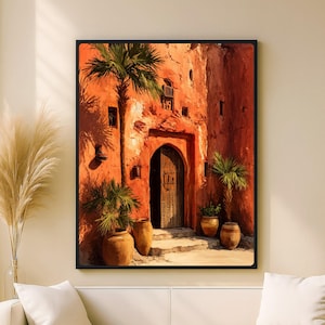 Peut inclure: Impression d'art encadrée représentant une porte marocaine ensoleillée. L'œuvre présente un bâtiment orange vif avec une porte en bois, des palmiers et des pots en terre cuite. La scène évoque la chaleur et le voyage.