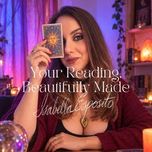 May include: A rectangular tarot card featuring a golden sun illustration on a dark blue background, held up by a person wearing a maroon cardigan, a black top, a lace choker, and a heart-shaped pendant necklace. Text reads: Your Reading, Beautifully Made, Isabella Esposito.