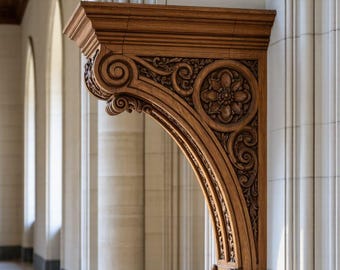 May include: Ornate wooden architectural bracket with carved floral and scroll designs. The bracket is a warm brown color and is mounted on a white wall. The background shows a hallway with columns and arches.