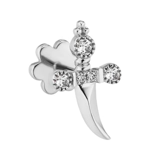 May include: A silver-toned dagger-shaped earring with clear, sparkling gemstones. The earring features a decorative crown at the top and a curved blade, with a flower-shaped backing. The jewelry is set against a white background.