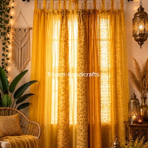 May include: Mustard yellow curtains with a tab-top header, featuring a mix of solid and intricate floral patterned panels. The curtains hang from a black rod, with a string of warm fairy lights and tassels draped above. Text reads Triveni-handicrafts.