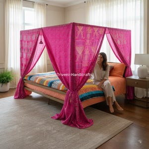 Könnte beinhalten: Ein leuchtend pinkfarbenes Himmelbett mit gemusterten Stoffvorhängen. Das Bett hat eine farbenfrohe, gemusterte Steppdecke und orangefarbene Bettwäsche. Der Raum hat neutral getönte Wände, Vorhänge und einen Teppich, was eine gemütliche und einladende Atmosphäre schafft.