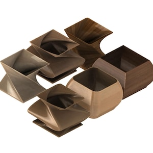 May include: An assortment of wooden decorative vases in various shapes and shades of brown. The vases include square, twisted, and rounded designs, showcasing a modern aesthetic. The wood grain is visible on some of the vases.