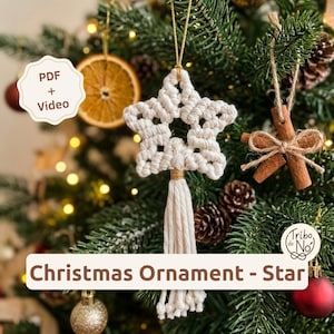 May include: A cream-colored macrame star ornament featuring a central star shape, a gold-wrapped accent, and a long fringe tassel. The ornament hangs from a gold string and includes text that reads PDF + Video and Christmas Ornament - Star.