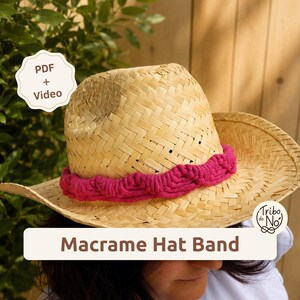 Puede incluir: Un sombrero de paja color canela claro con una banda de macramé color magenta vibrante con un patrón trenzado. La imagen incluye el texto PDF + Video, Tribo do No y Macrame Hat Band. El sombrero tiene un ala ancha y una copa estructurada.