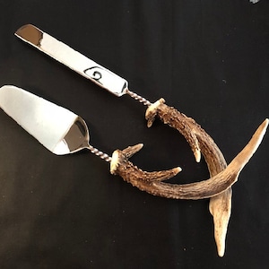 May include: A silver cake server and knife set with antler handles. The handles are a natural brown colour and have a twisted design.