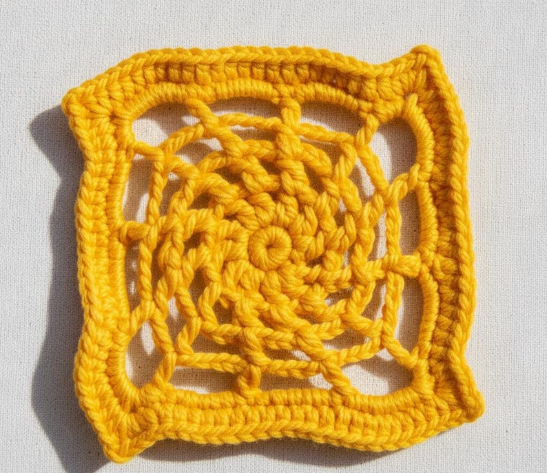 May include: A square, handmade crochet doily in a vibrant yellow hue. The intricate design features a central spiral pattern surrounded by openwork and a solid border. The texture is clearly visible, showcasing the yarn's loops and knots.